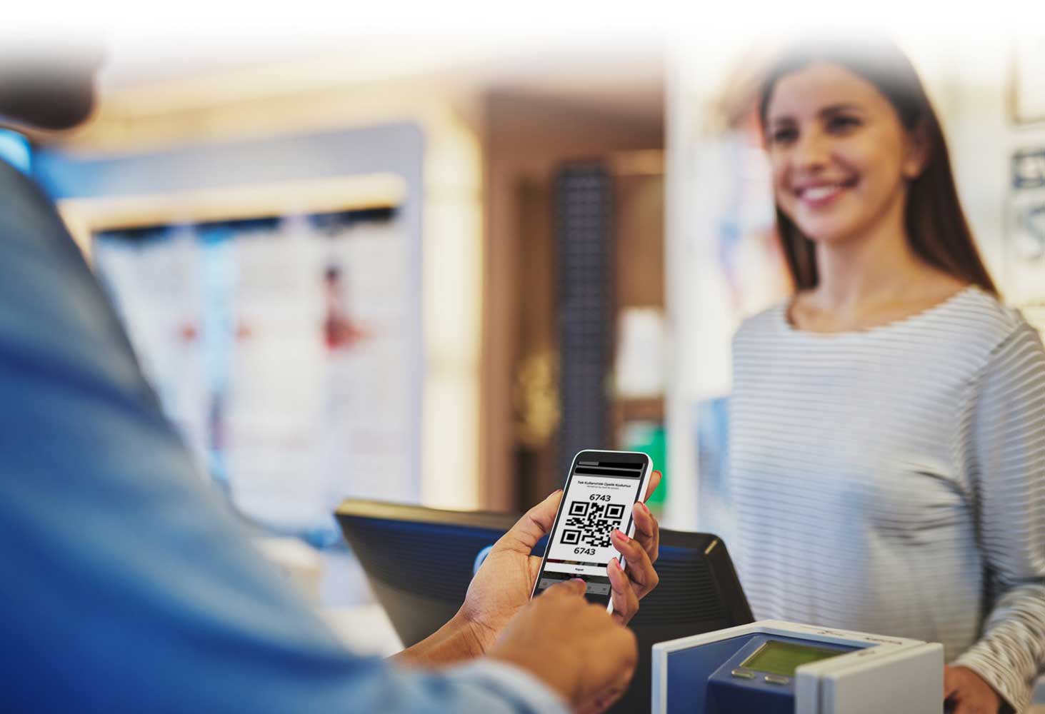 Kasada bir müşteri telefonundaki sadakat QR kodunu gösteriyor